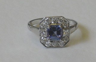 An 18ct white gold dress ring set a square cut tanzanite surrounded by numerous diamonds