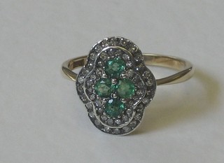 An 18ct yellow gold dress ring of shaped form set 3 emeralds supported by diamonds