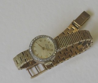 A lady's Girard-Perregaux wristwatch contained in a 9ct gold case with integral bracelet, the bezel surmounted by numerous diamonds