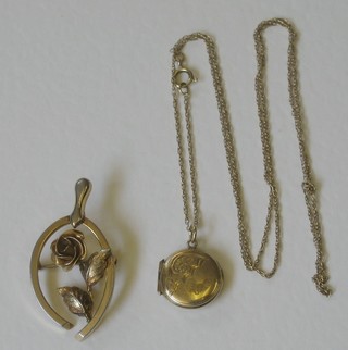 A gilt metal locket hung on a gilt chain and a gilt metal brooch
