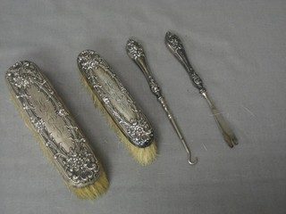 2 silver backed clothes brushes and a silver handled button hook and 1 other implement