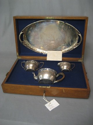 An Edwardian 4 piece silver tea service, London 1903 by Charles Stewart Harris & Sons comprising pierced oval twin handled tea tray, sugar bowl, cream jug and teapot, 70.5 ozs, contained in an oak box