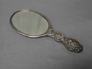 An embossed silver backed hand mirror (some holes)