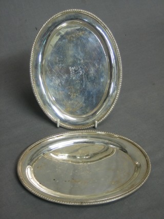 A pair of oval silver plated sauce boat stands with armorial decoration and gadrooned borders 7 1/2"