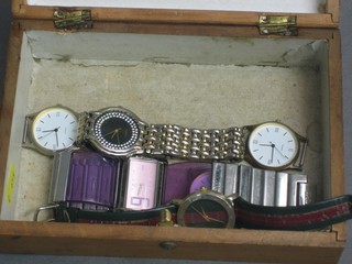 A Victorian walnut box containing a collection of various wristwatches