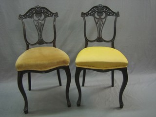 A pair of Edwardian mahogany slat back dining chairs with vase shaped backs and upholstered seats, raised on cabriole supports