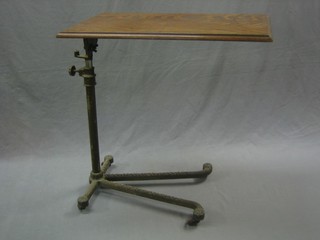 An Edwardian oak invalid table, raised on an iron stand by Carters 