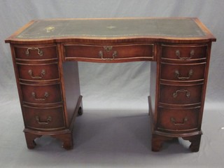 A Georgian style mahogany kneehole pedestal writing desk of serpentine outline, with inset green leather writing surface, above 1 long and 8 short drawers, raised on bracket feet 45"