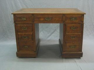 An Edwardian oak kneehole pedestal desk with inset tooled leather writing surface above 1 long and 6 short drawers 42"