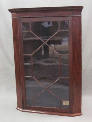 A 19th Century mahogany hanging corner cabinet, the interior fitted shelves enclosed by an astragal glazed panelled door 33"