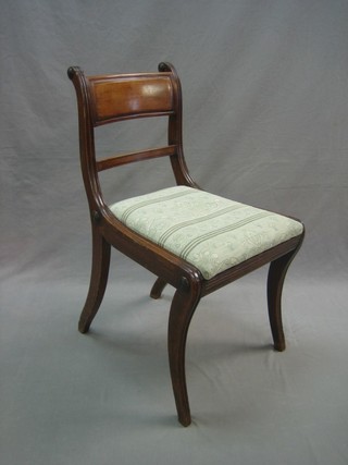 A Regency mahogany bar back dining chair with plain mid rail and upholstered drop in seat, raised on sabre supports