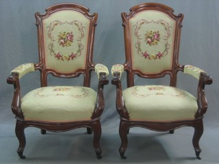 A pair of Continental mahogany open arm chairs, the seats and backs upholstered in Berlin woolwork, raised on cabriole supports