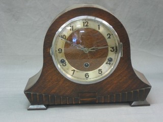 An Art Deco chiming mantel clock with silvered dial and Arabic numerals contained in an arch shaped oak case