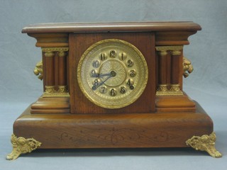 A 19th Century American 8 day striking mantel clock with embossed gilt dial with Arabic numerals contained in a walnut case