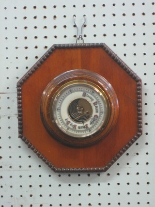An aneroid barometer with porcelain dial contained in an octagonal walnut shaped case 4"