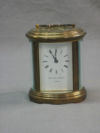 A 20th Century Swiss 8 day carriage clock with enamelled dial marked Matthew W Norman of London, contained in an oval gilt case