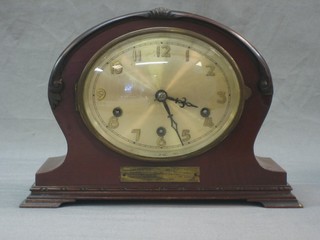 A 1930's chiming mantel clock with oval silvered dial and Arabic numerals contained in a mahogany shaped case, raised on ogee bracket feet 6"