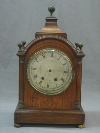 An Edwardian striking bracket clock with 6" circular dial and Roman numerals contained in an oak case with brass finial to the top (no hands, movement loose)