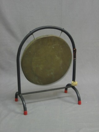 A circular brass tea gong, raised on an iron stand 14"