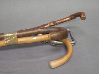 A metal shooting stick and various walking sticks