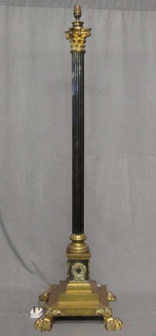 A handsome brass standard lamp with reeded column and Corinthian column capital, raised on a stepped base with paw feet 48"