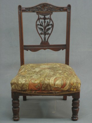 A Victorian carved walnut nursing chair with vase shaped splat back and upholstered seat, raised on turned supports