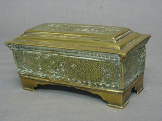 A rectangular Eastern embossed brass trinket box with hinged lid, raised on bracket feet 6"