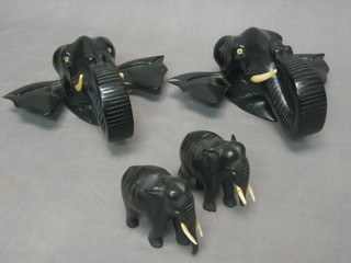 A pair of ebony wall masks in the form of elephant masks together with a pair of ebony elephants