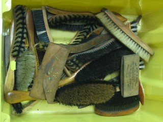 A yellow plastic container containing a collection of various advertising clothes brushes