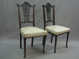 A pair of Edwardian mahogany slat back bedroom chairs with seats upholstered in Regency stripe