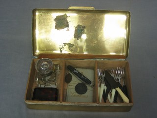 A rectangular brass cigarette box with hinged lid containing a tortoiseshell finished match slip, a square carved inkwell and a carved wooden letter opener