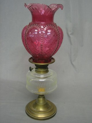 A Victorian glass oil lamp reservoir with red glass shade