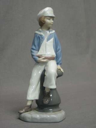 A Lladro figure of a seated boy with sailing boat, the base impressed 4810 9"