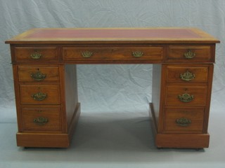 An Edwardian walnut kneehole pedestal desk with inset leather writing surface above 1 long and 8 short drawers, 48"