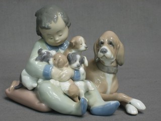 A Lladro figure group of seated dog with boy and puppies (dog paw chipped) 4"