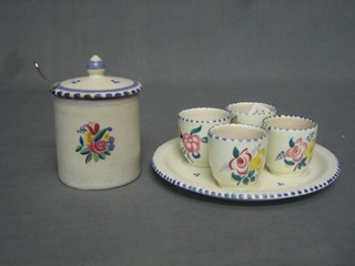 A cylindrical Poole Pottery preserve jar with impressed mark to base (chips to lid) 3" and a Poole egg cruet with tray and 4 egg cups