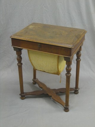 A Victorian figured walnut sewing box with hinged lid and deep basket to the front, raised on turned supports united by an X framed stretcher 20"