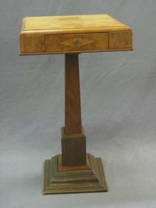 An Art Deco figured walnut pedestal chess table, the top inlaid a chessboard, the base fitted a drawer and raised on a square tapering column 17"