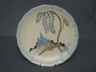 A circular Clarice Cliff charger decorated a tree and stylised landscape, the reverse impressed 438, 11"