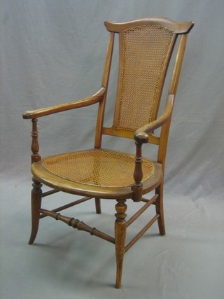 A walnut open arm chair with woven cane seat and back, raised on turned supports