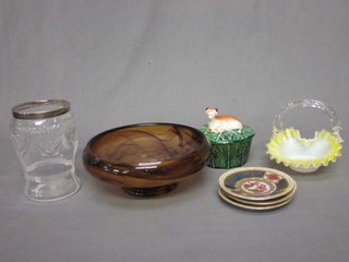 A cylindrical cut glass vase with silver collar 6", a brown glass bowl 9", a vaseline glass basket 5", 4 Berlin style saucers 3" and a circular butter dish and cover in the form of a seated cow