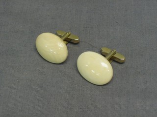 A pair of oval ivory T bar cufflinks