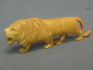 A carved ivory figure of a walking lion