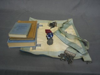 A quantity of Masonic regalia including a Past Master's apron, 2 gilt metal and enamelled steward's jewels, a Governors' jewel, various books