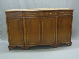 A Georgian style figured walnut breakfront sideboard, the centre section fitted 2 drawers above a double cupboard flanked by 2 drawers, raised on bracket feet 60"