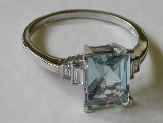 A lady's 18ct gold white gold dress ring set a rectangular cut aquamarine and with 2 baguette cut diamonds to the shoulders