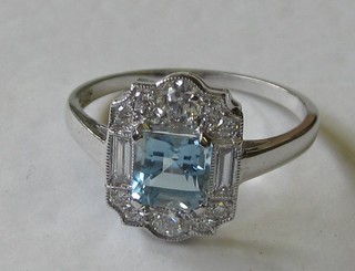 An 18ct white gold dress ring set a square cut aquamarine surrounded by diamonds and with diamonds to the shoulders approx 0.50ct