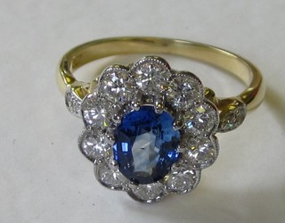 An 18ct yellow gold dress ring set an oval cut sapphire surrounded by numerous diamonds, approx 0.95/1.45ct