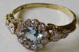 A lady's 18ct yellow gold dress ring set a circular aquamarine surrounded by diamonds