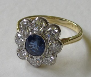 An 18ct yellow gold dress ring set a circular cut sapphire surrounded by diamonds approx. 1.15/1.30ct